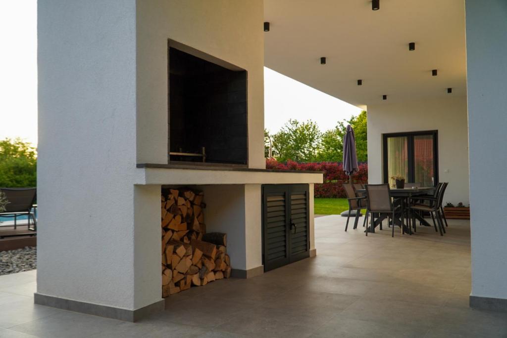 Covered terrace with an outdoor fireplace and dining table