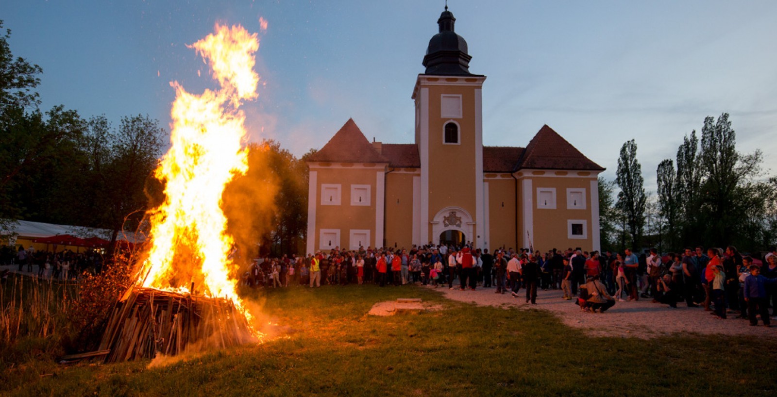 Lukavec Castle during a traditional gathering beside a bonfire